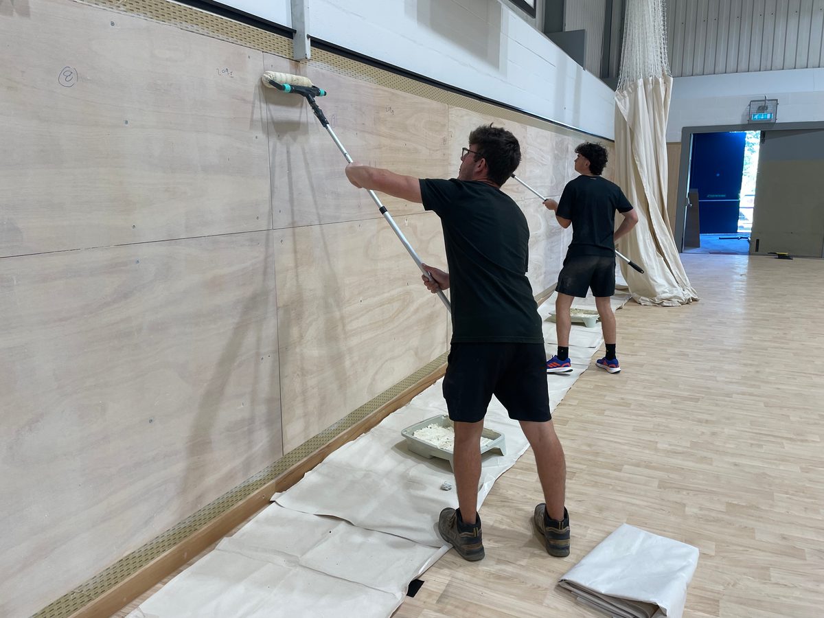 Rolling adhesive onto plywood walls for Softwall