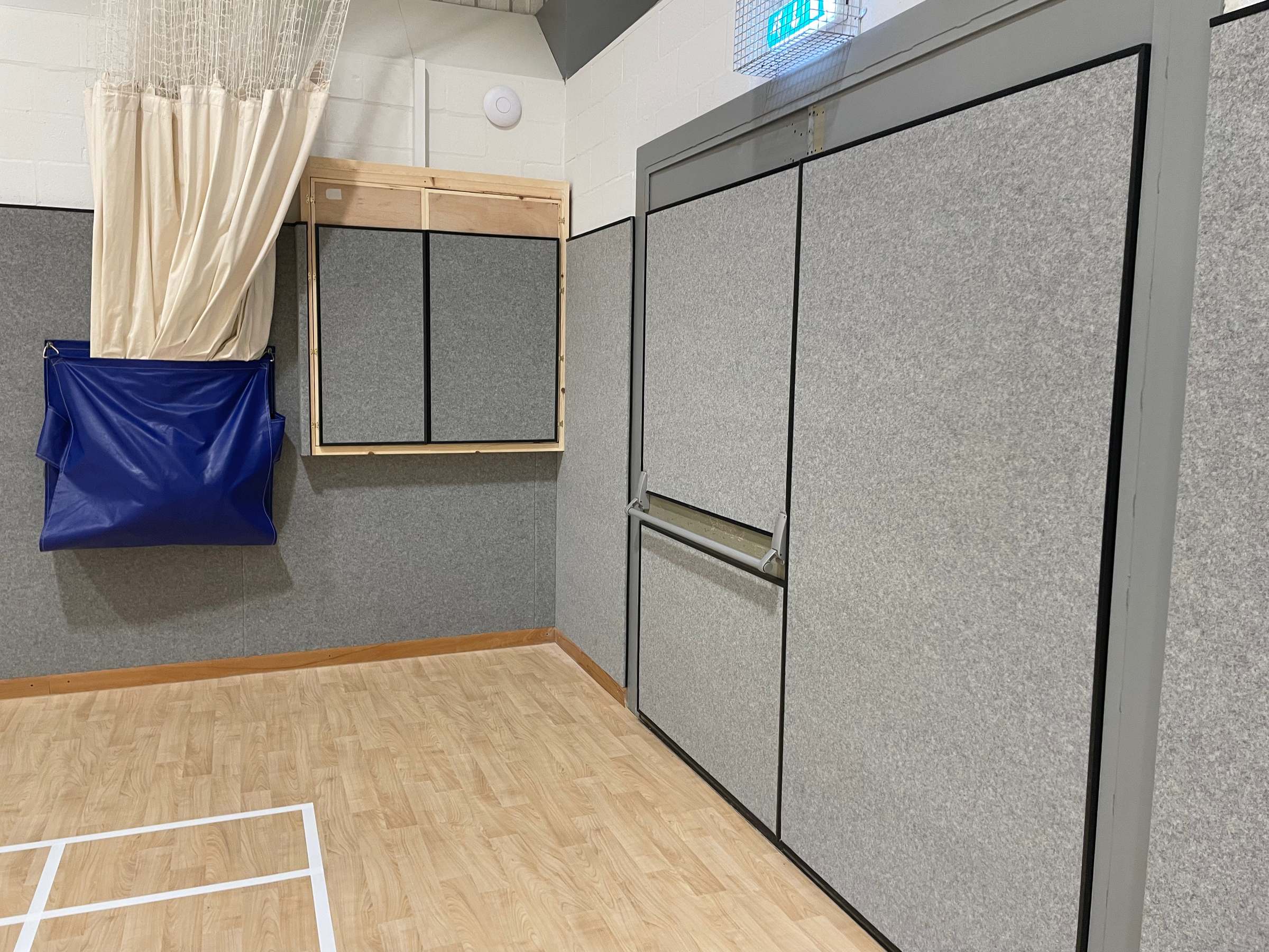 Grey Softwall anti-shock panels lining a sports hall